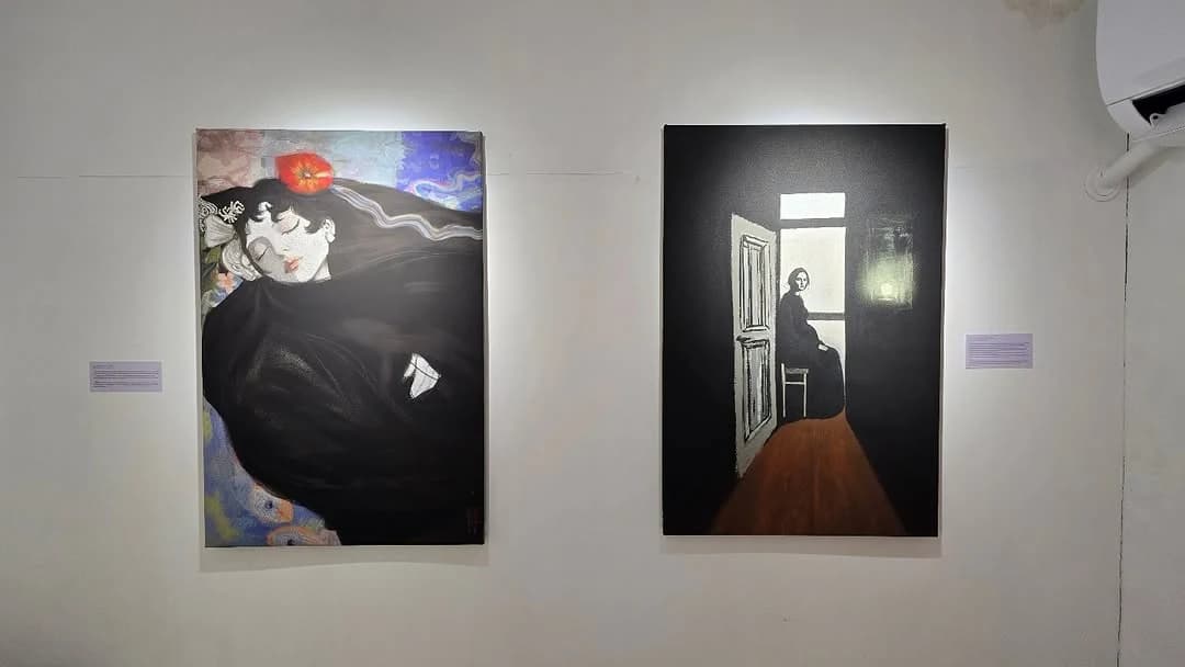 Two paintings installed side by side with gallery labels at Light That Remains