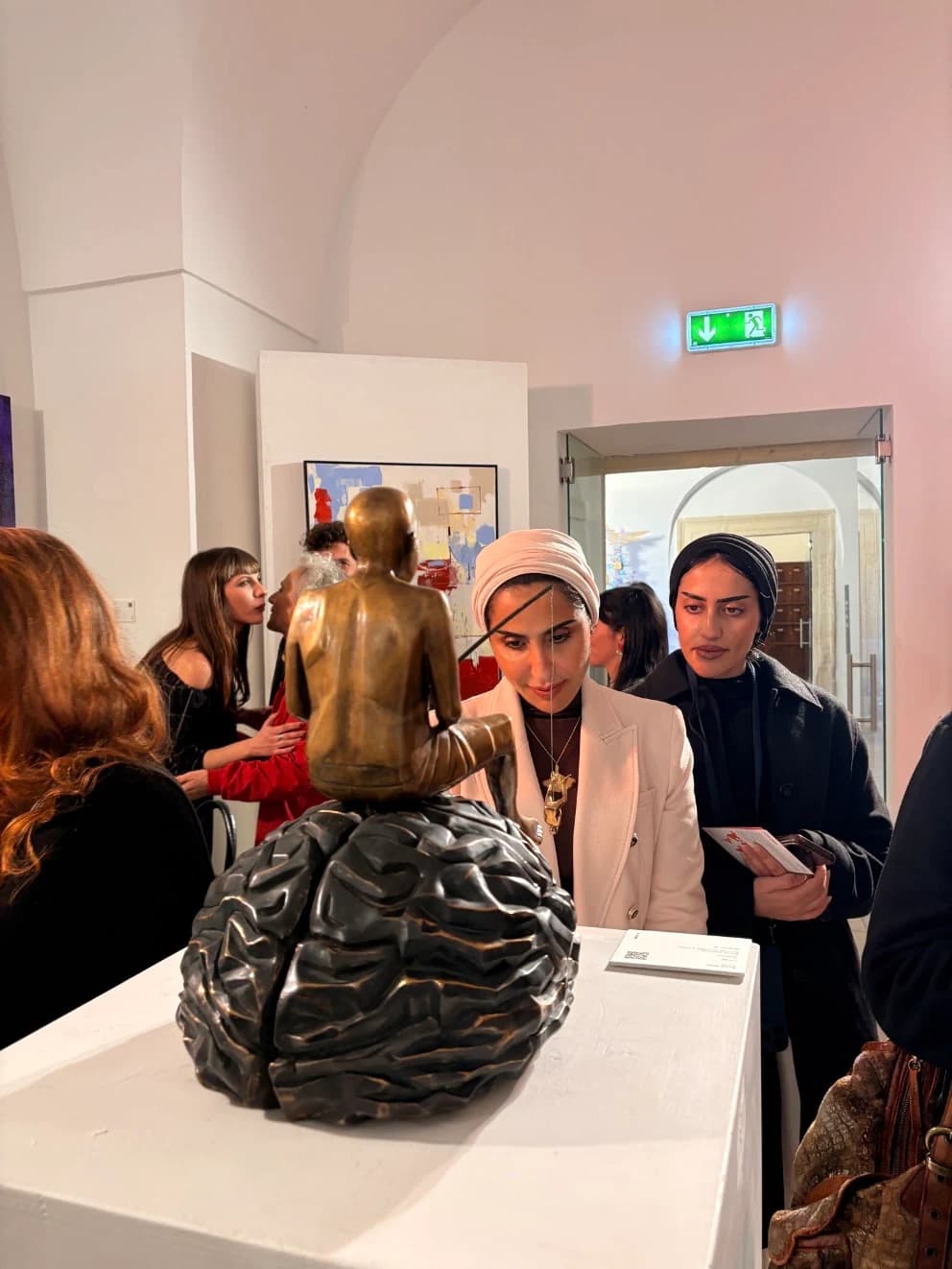Visitors viewing a sculpture and paintings at Senses International Art Fair
