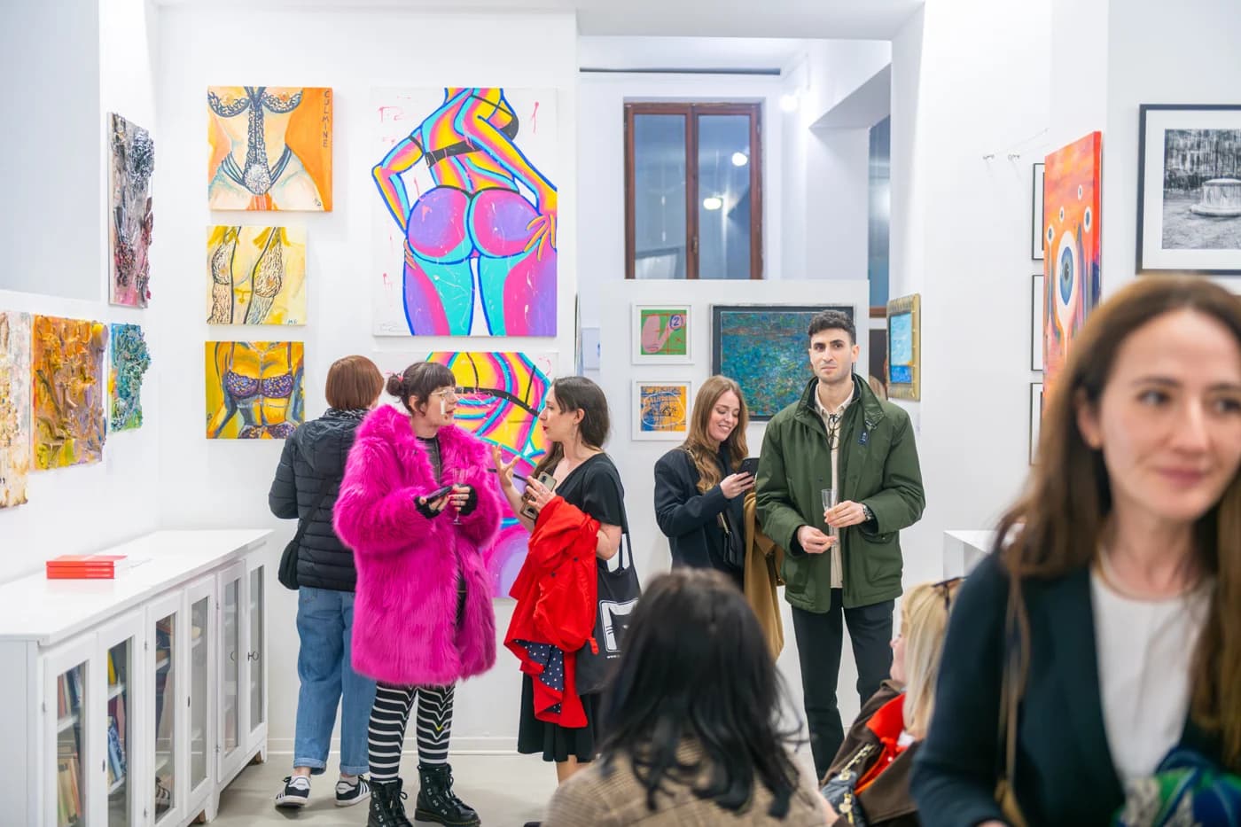 Visitors gathering among the displayed paintings at Contemporary Venice
